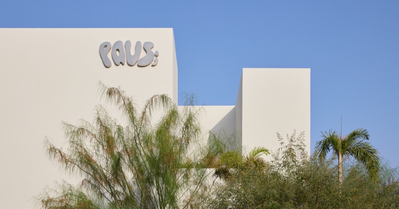 The Paus Club building framed by greenery